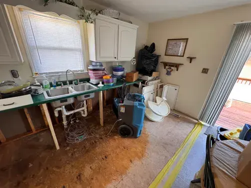 Kitchen floor opened with a dehumidifier drying the subfloor in a Wake Forest home