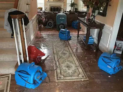Air movers drying a wet hardwood hallway in a Wake Forest home