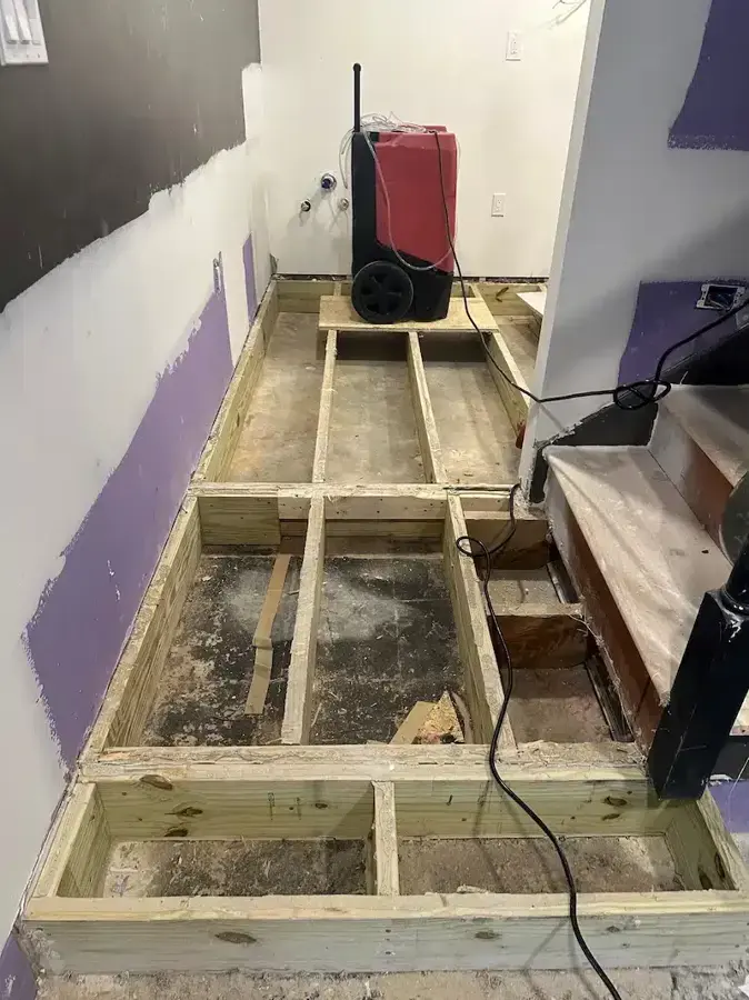 Subfloor opened for drying with a dehumidifier in Wake Forest