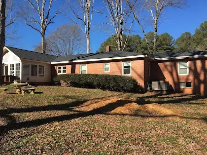 Brick ranch home under tall trees, typical of older Wake Forest neighborhoods