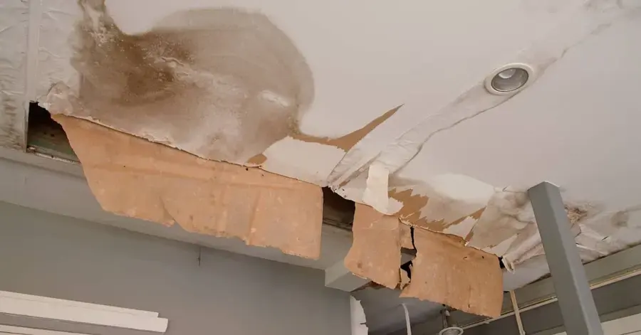 Sagging, torn ceiling drywall soaked by a leak above in Wake Forest