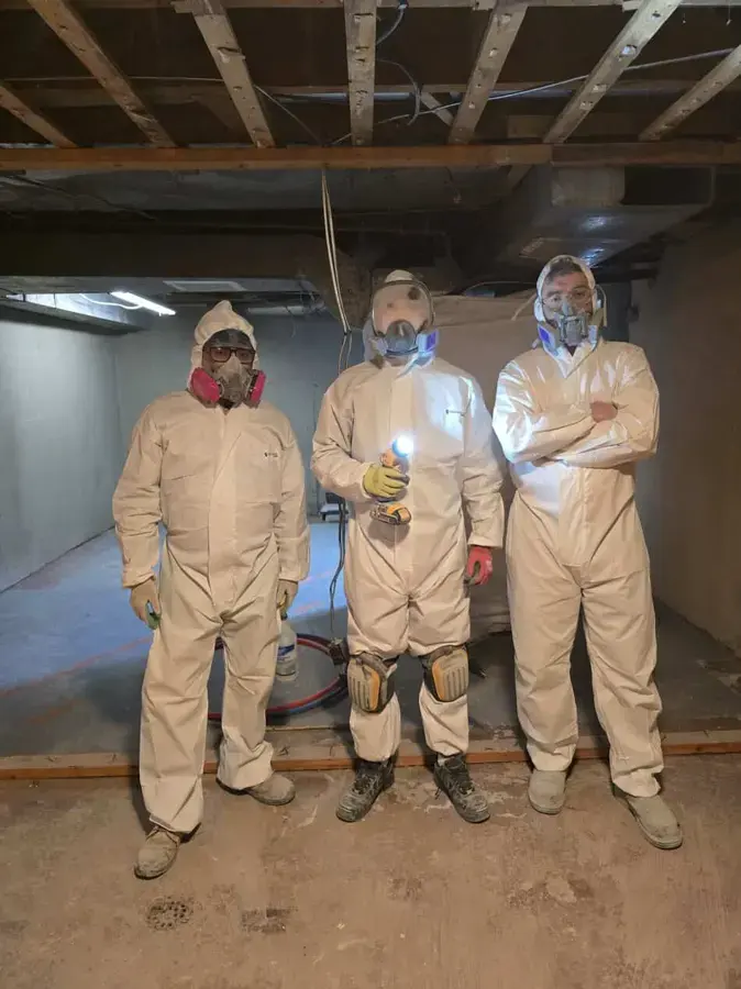Cleanup crew in protective suits and respirators for a Wake Forest sewage backup